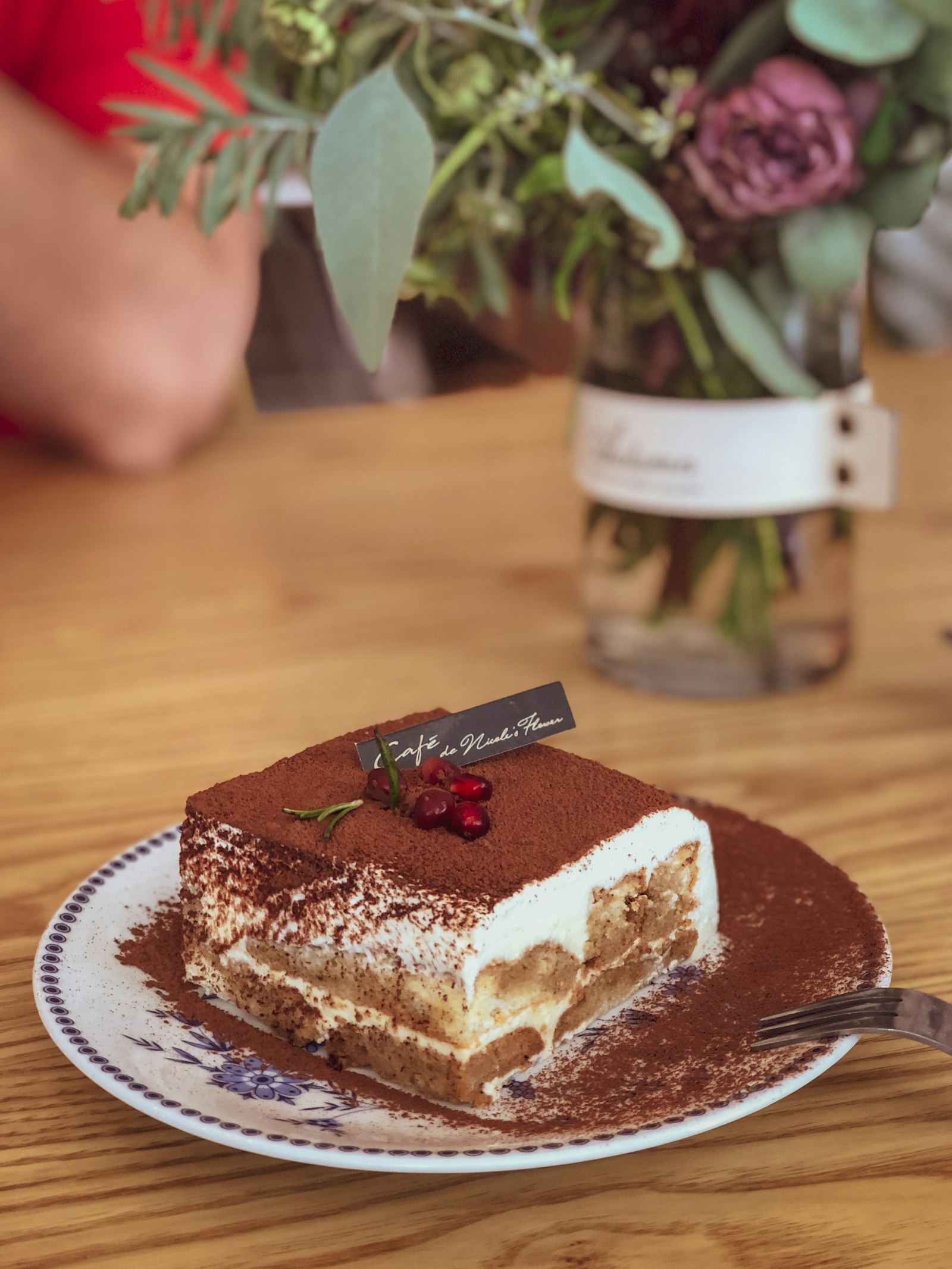A slice of homemade tiramisu dusted with cocoa on a plate